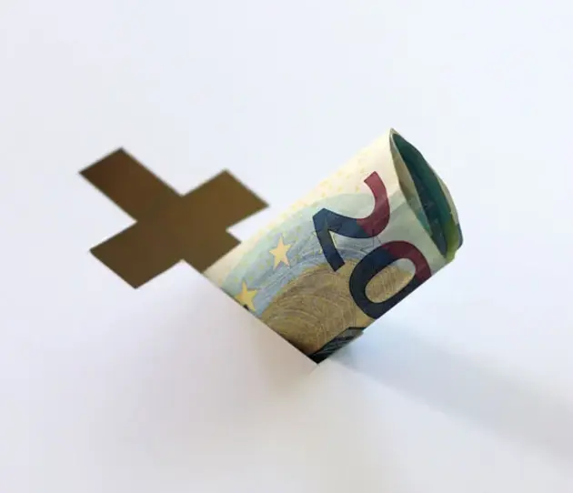 Geldschein und Kreuz - Wirtschaft und Kirche