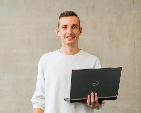 Student mit Laptop in der Hand
