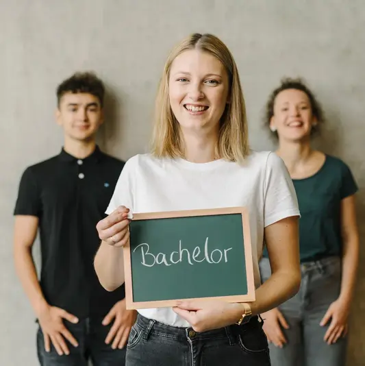 Studierende mit Bachelor-Schild